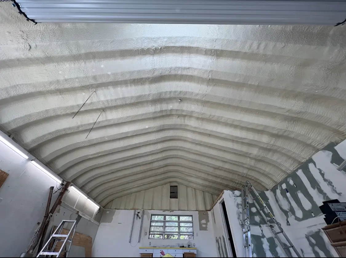 Spray polyurethane foam applied to the underside of a metal roof deck in Clute